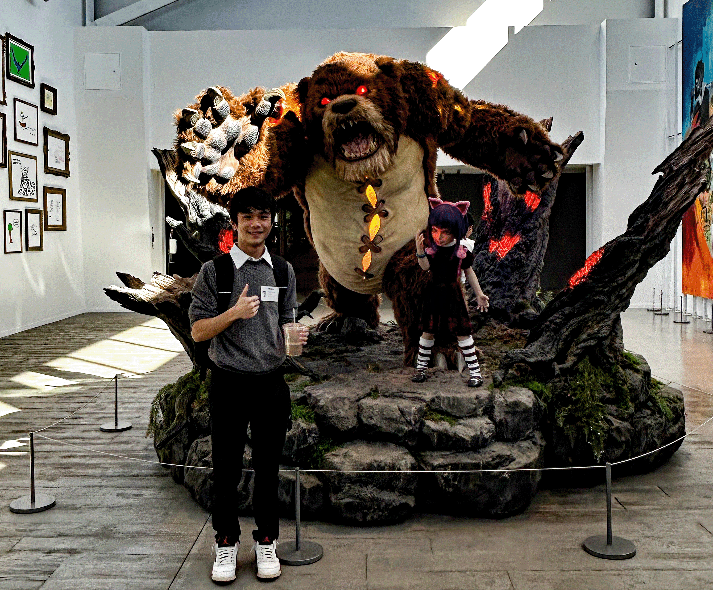 a picture of me with black pants and gray sweater standing next to a bear statue