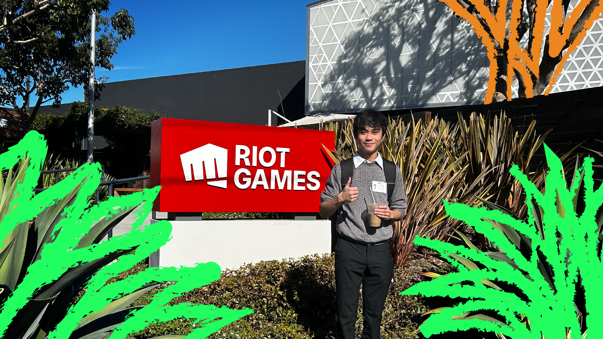 A picture of me with black pants and grey sweater next to the Riot Games sign outside